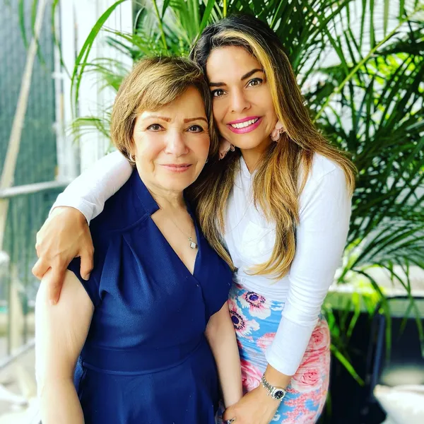 A woman and her daughter posing for the camera.