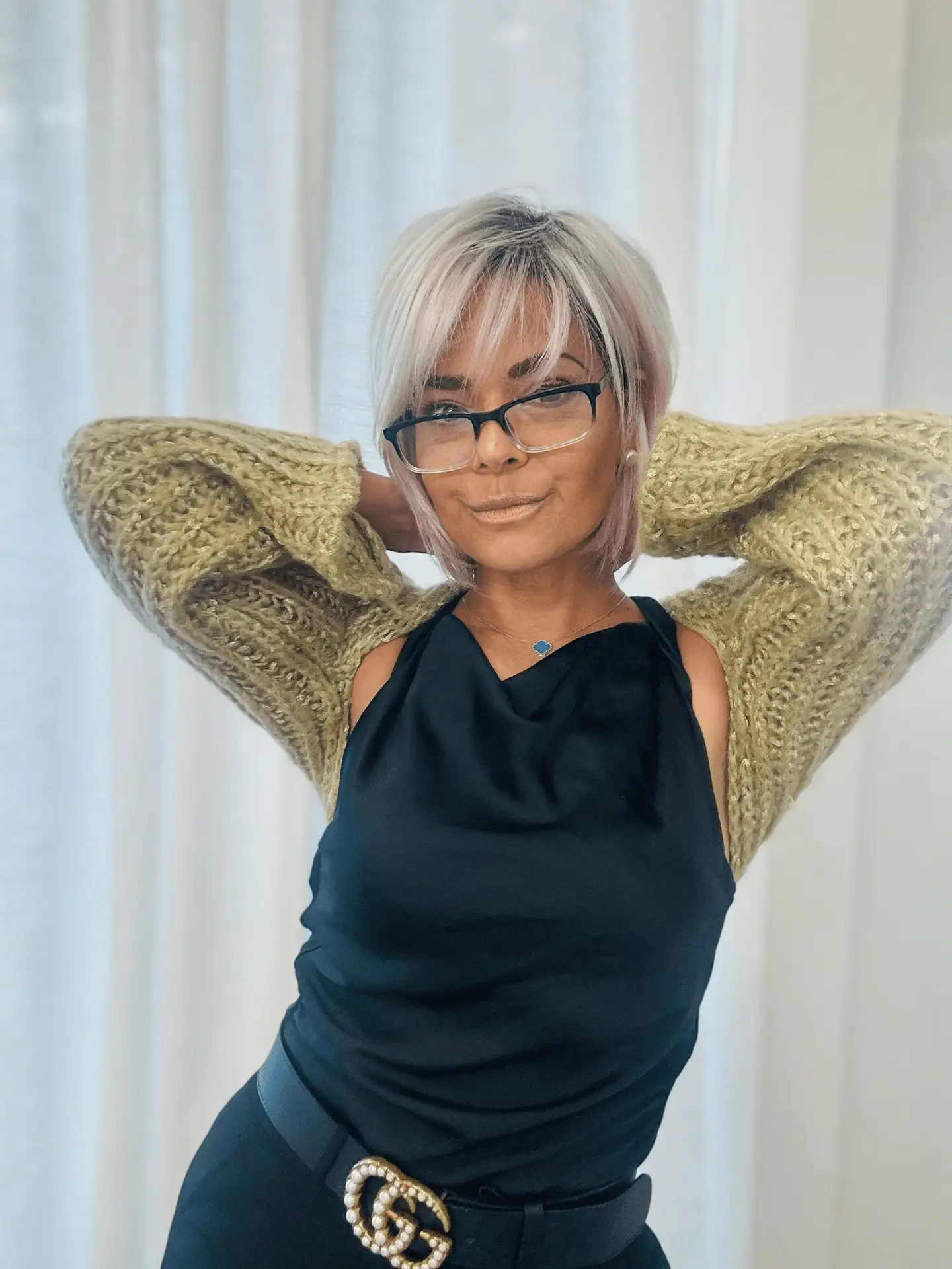 A woman with glasses and a sweater on.