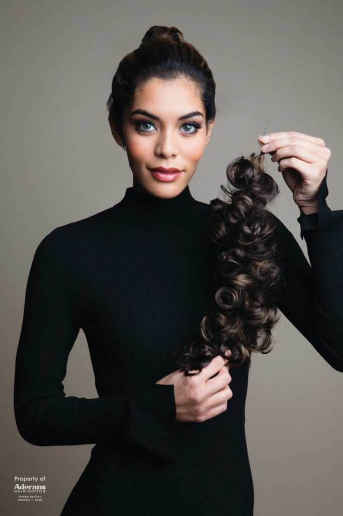 A woman holding her hair in front of the camera.