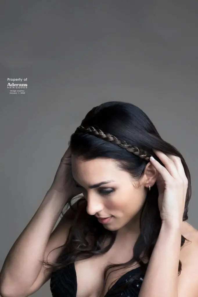 A woman with long hair is holding her head