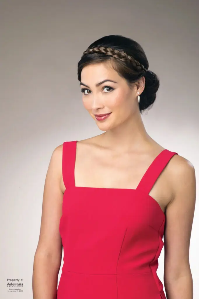 A woman in red dress with braid on her head.