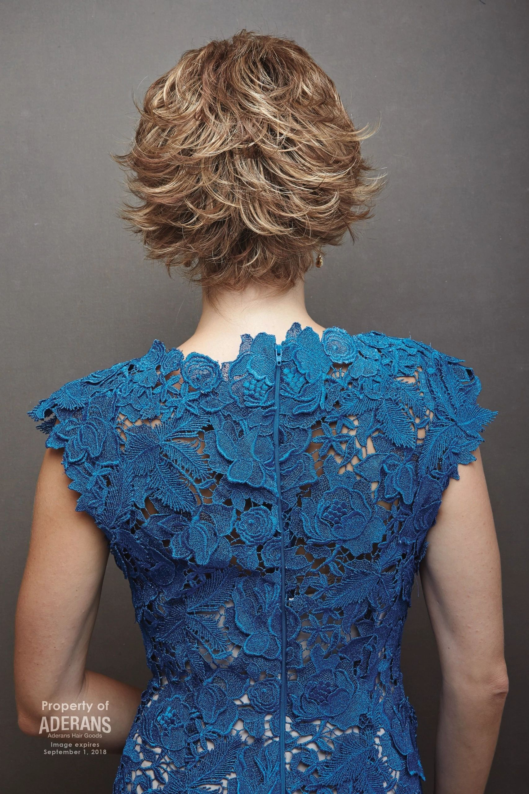 A woman in blue dress with short hair.