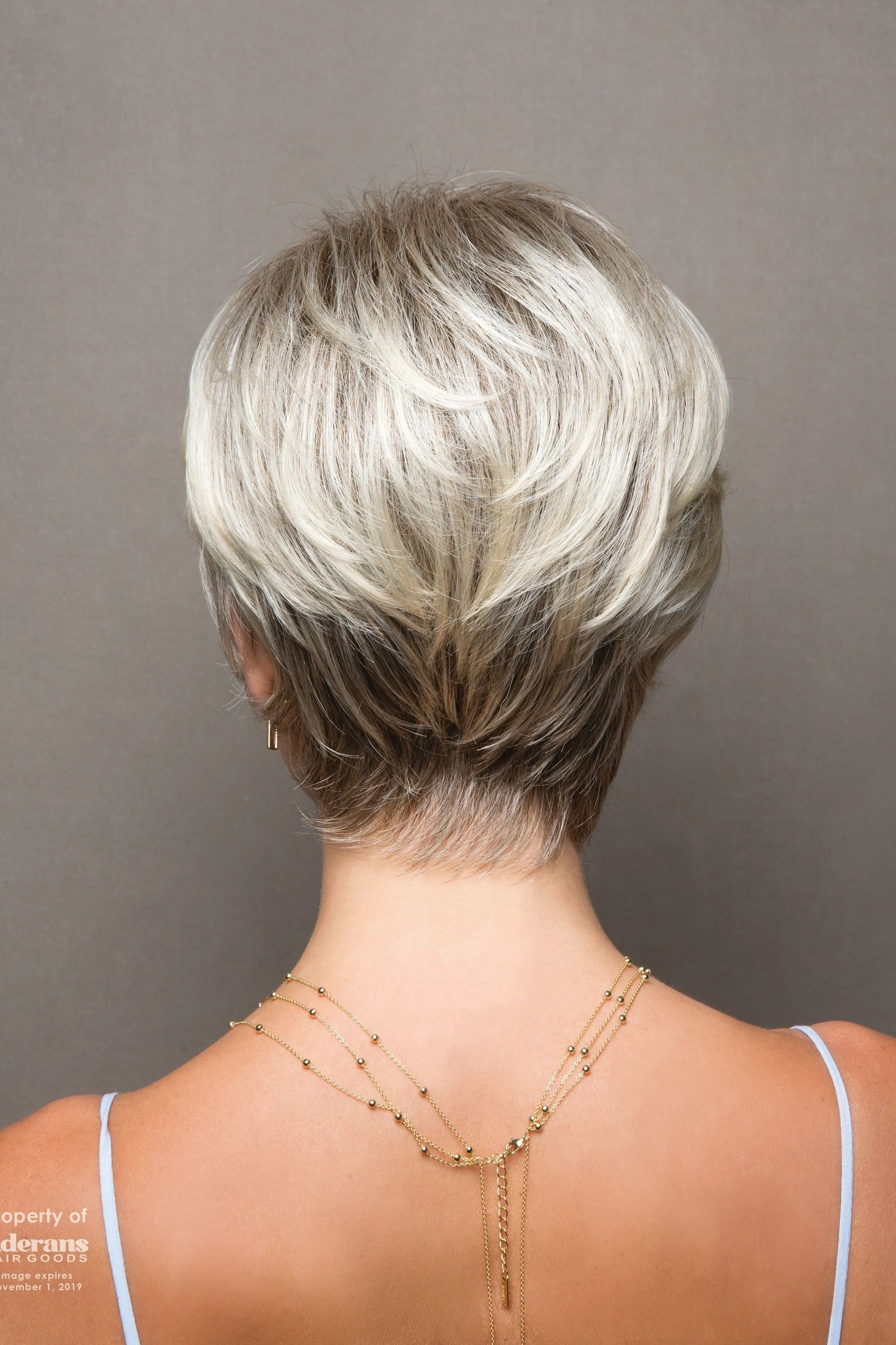 A woman with short hair is wearing a necklace.