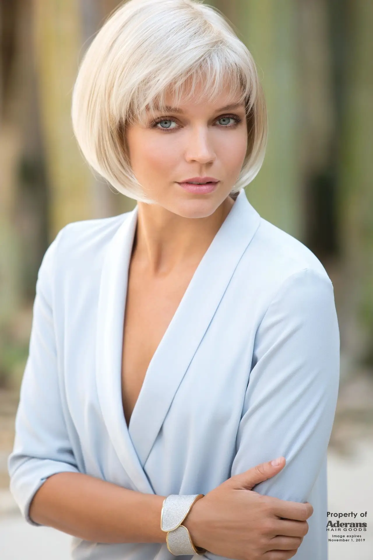 A woman with short blonde hair wearing a blue shirt.