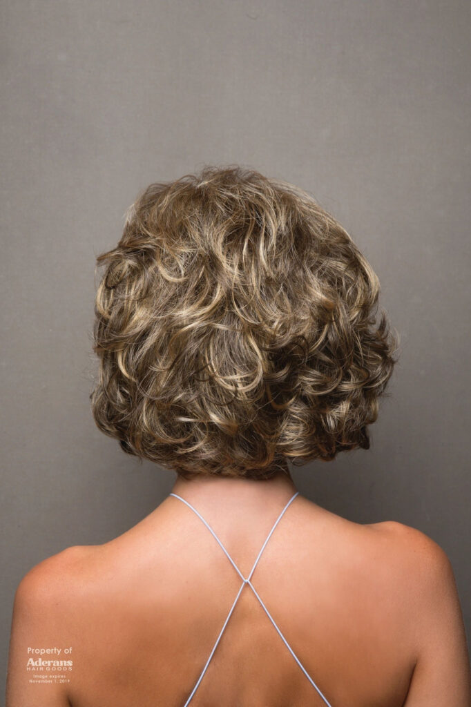 A woman with short hair is wearing a necklace.