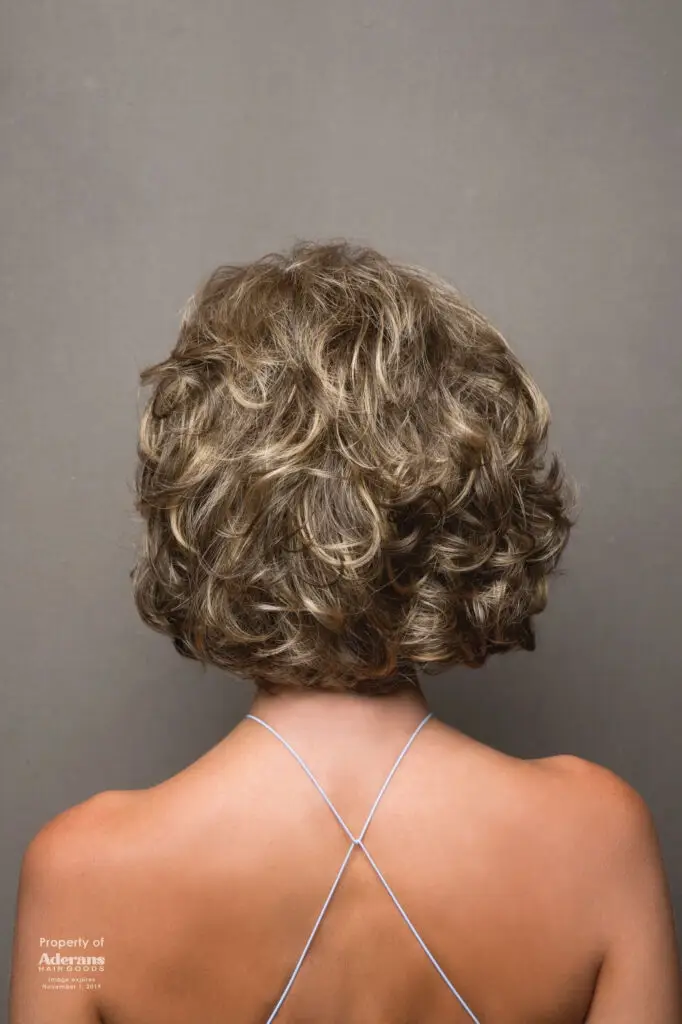 A woman with short hair is wearing a necklace.